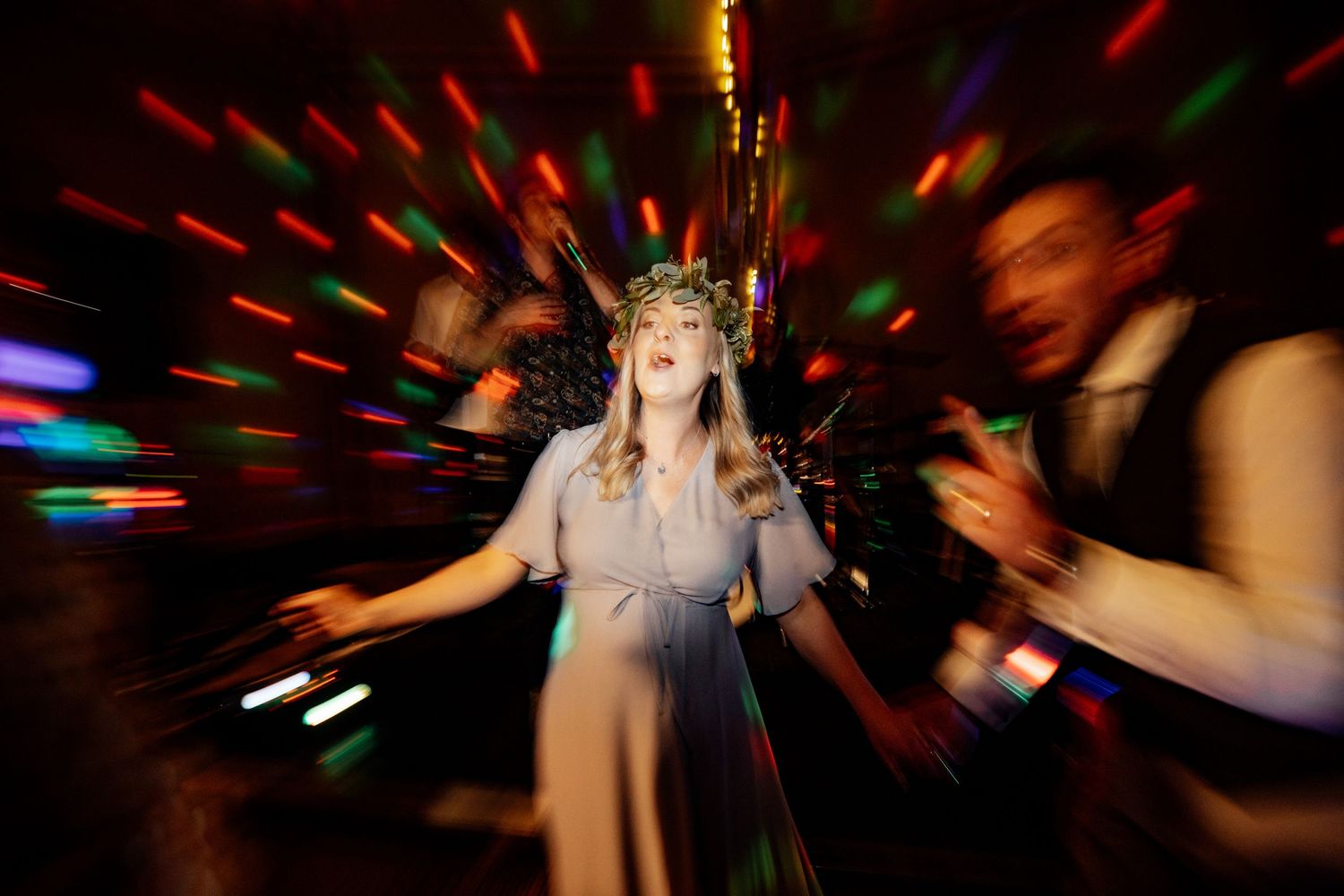 Blurred dance floor scene with red lighting and motion effects.
