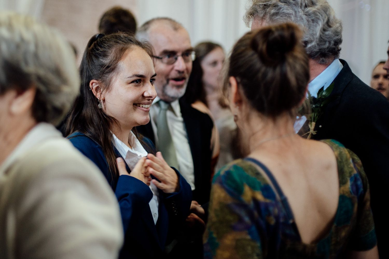 Wedding guests enjoying a lively dance party celebration at an indoor reception venue.