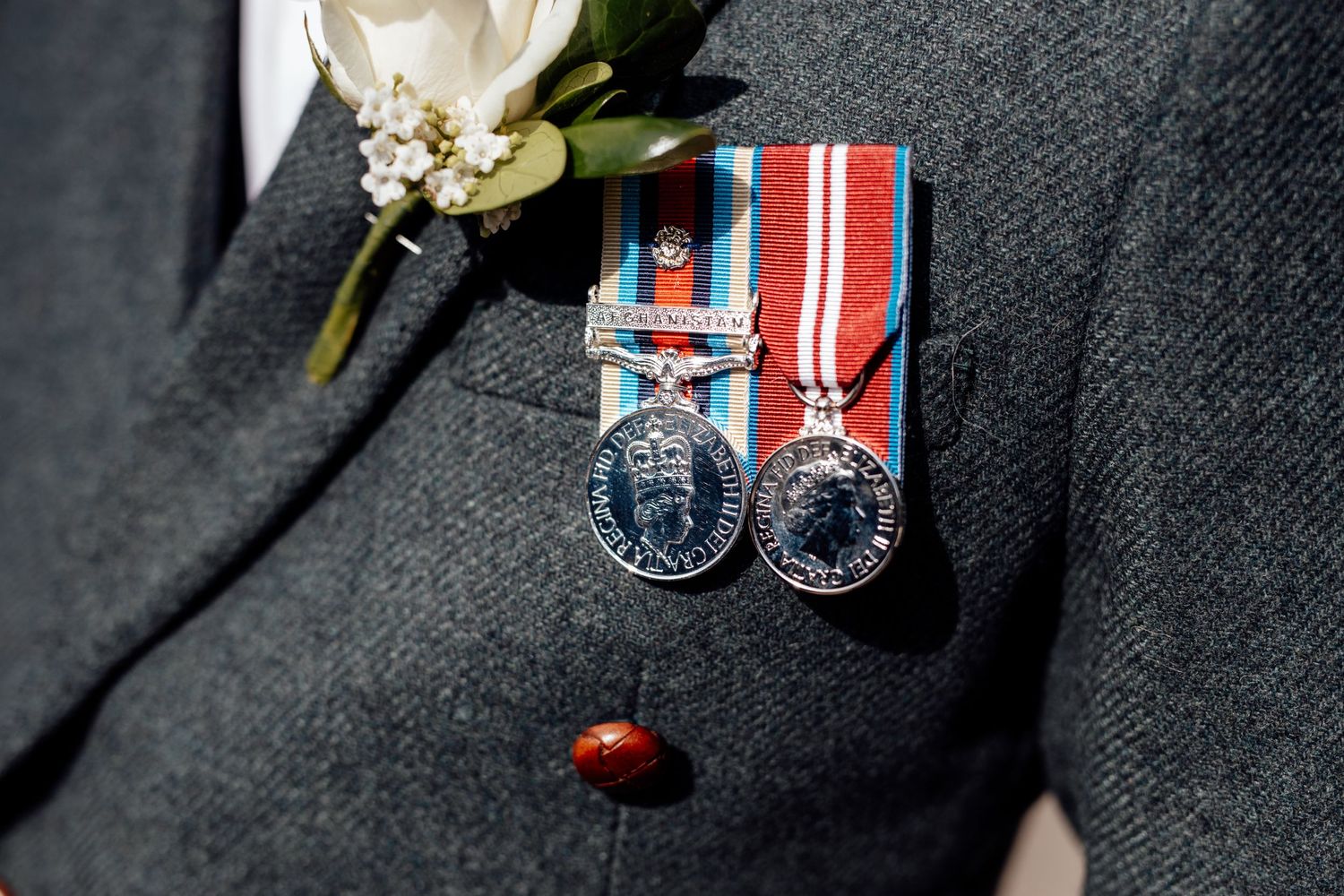 Close-up of military medals and decorations on dark formal attire.