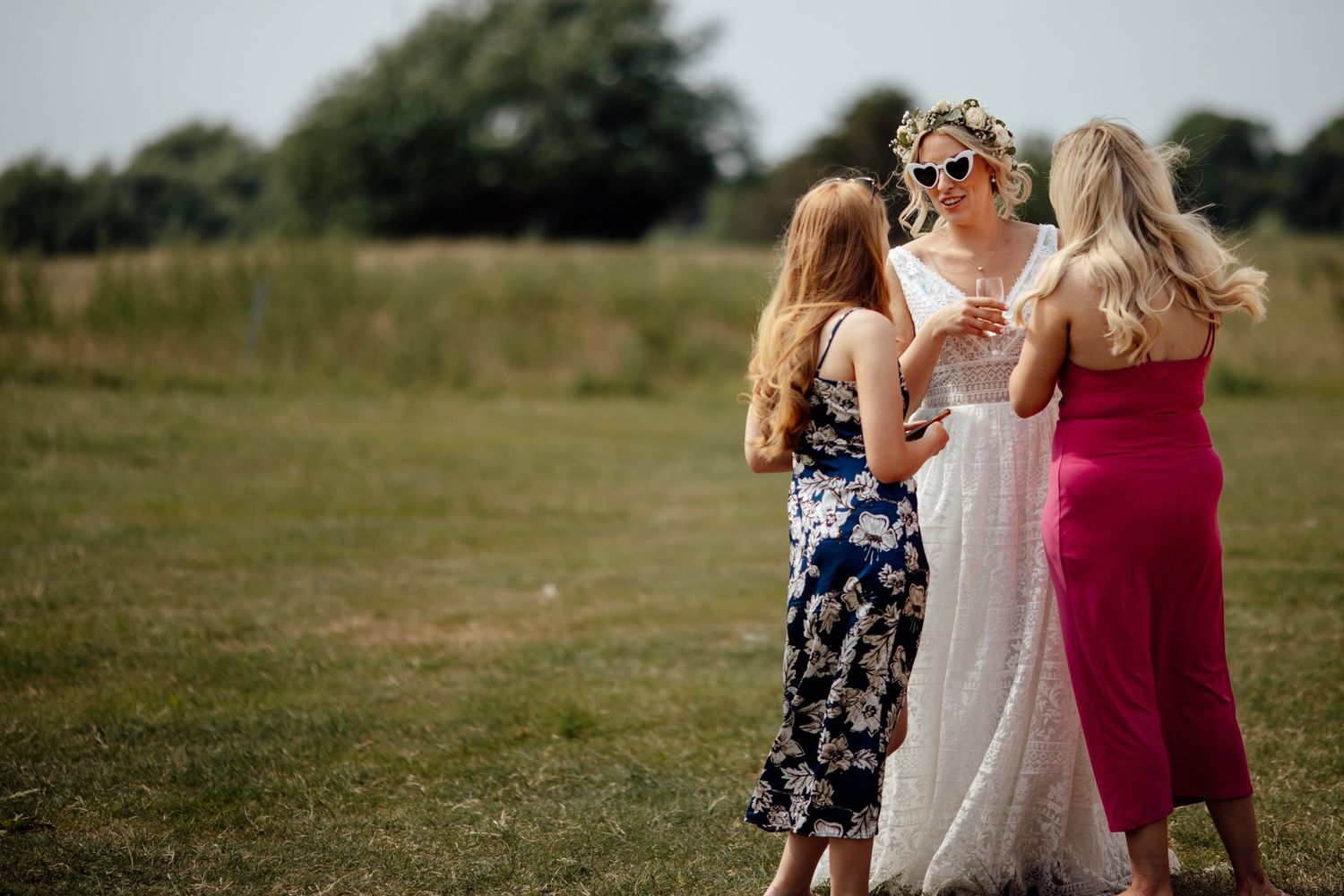 Wedding guests enjoying outdoor celebration in summer garden setting.