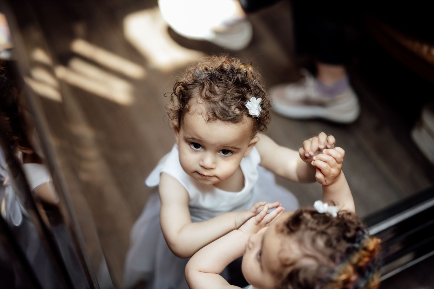A young child in formal attire plays during a wedding celebration.