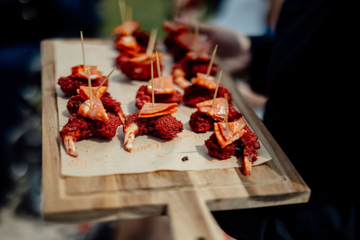 Appetizers beautifully displayed on wooden serving boards at a catered event.