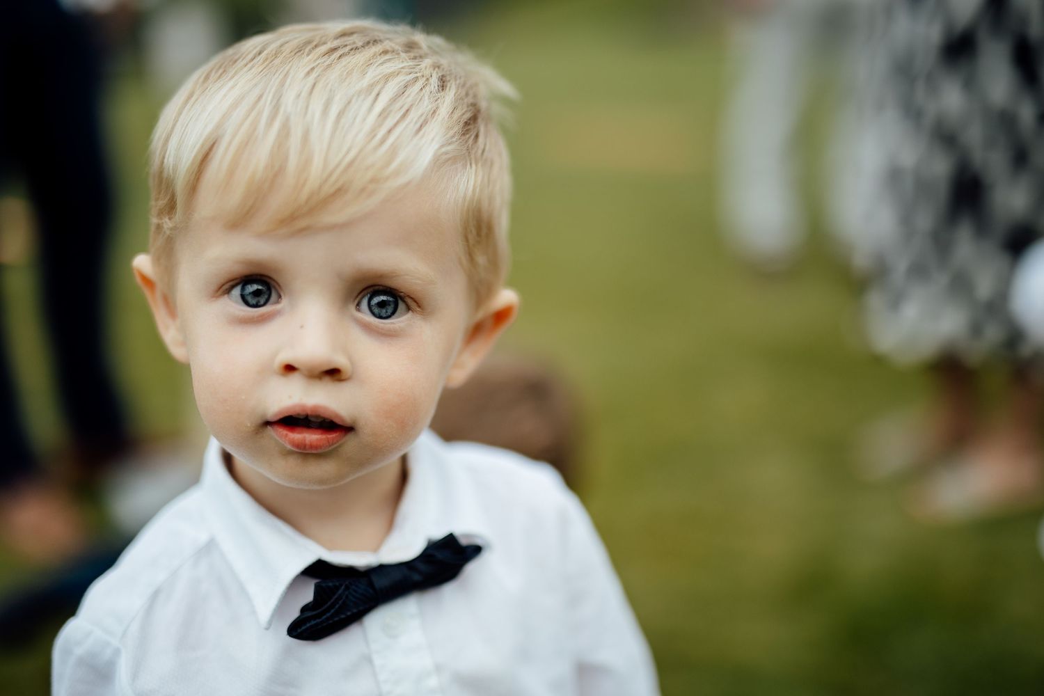 Child in formal white attire at an outdoor event.