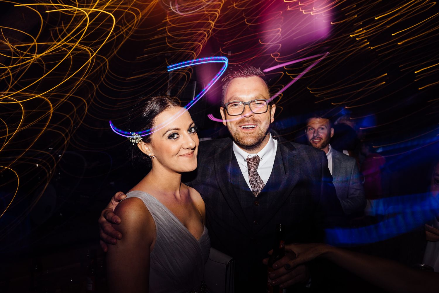 Wedding reception dance floor with colorful lighting and party atmosphere.
