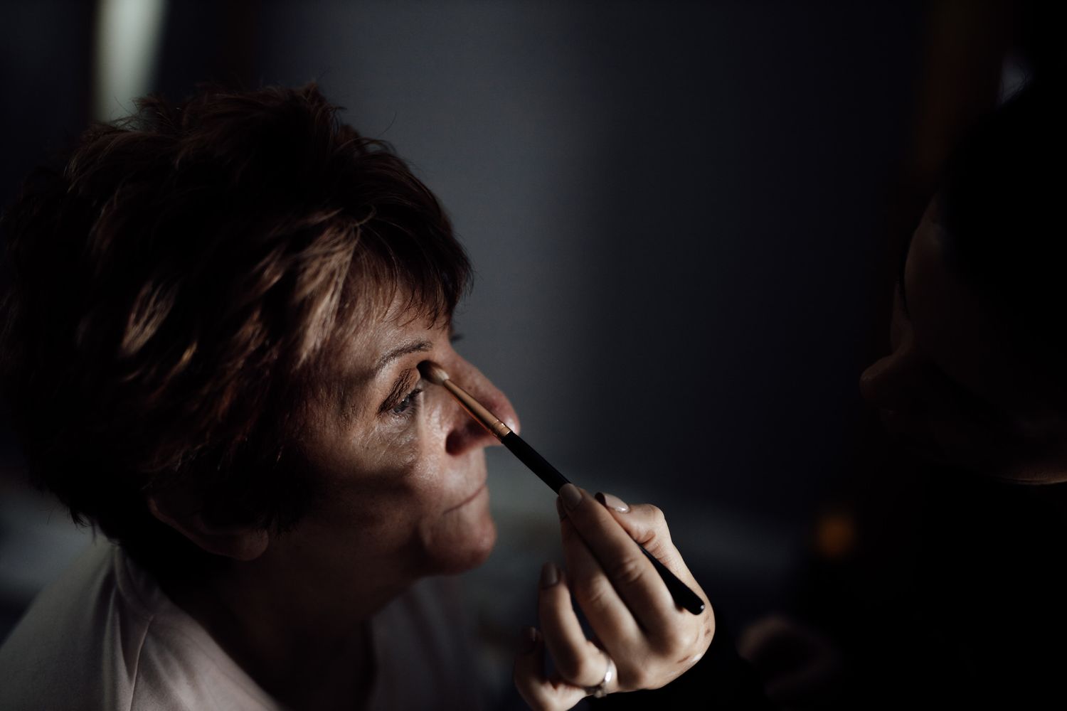 Dramatic low-key portrait series with dark shadows and emotional expressions.