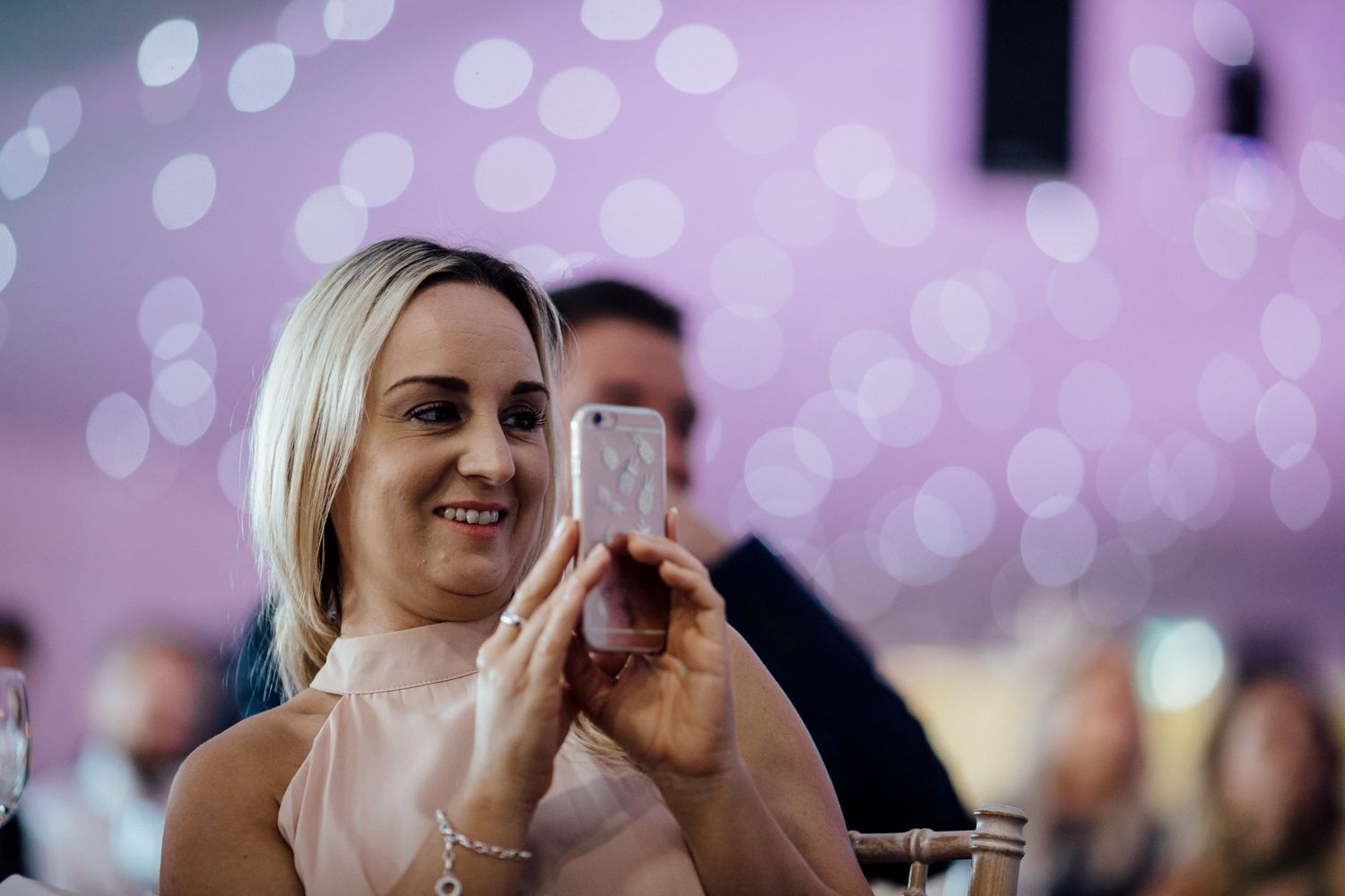 Purple bokeh lights create a dreamy atmosphere at an indoor celebration.