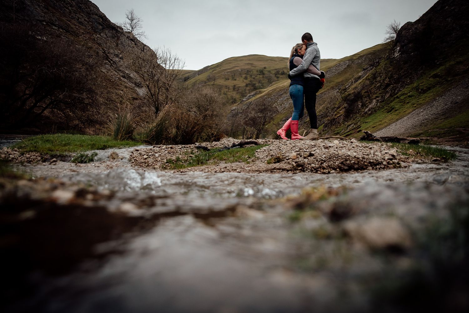 A romantic moment captured from a low angle near a mountain stream.