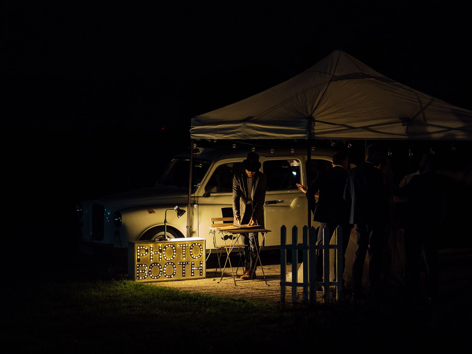 Outdoor wedding venue lit up at night with ambient lighting.