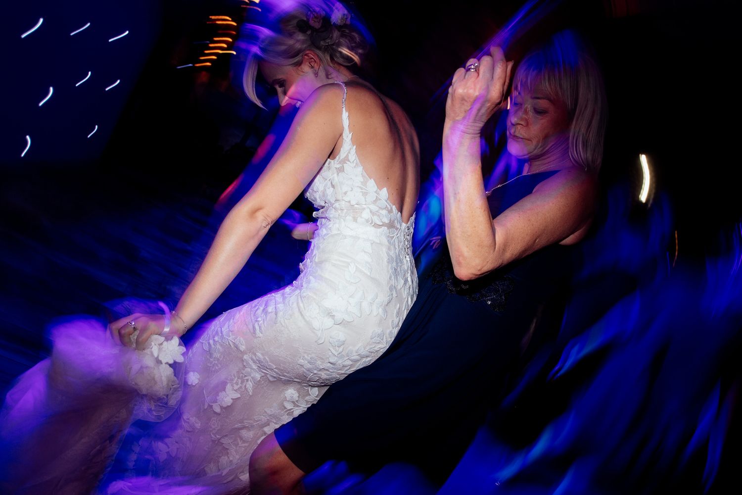 Wedding dance floor scene with blue mood lighting and silhouettes.
