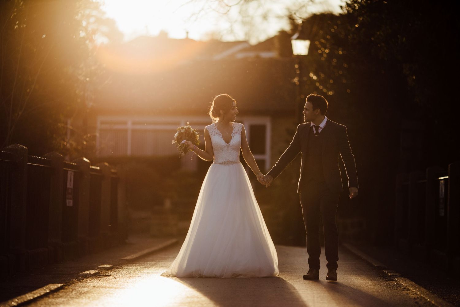 Dramatic backlit wedding photography with golden sunlight streaming through trees.
