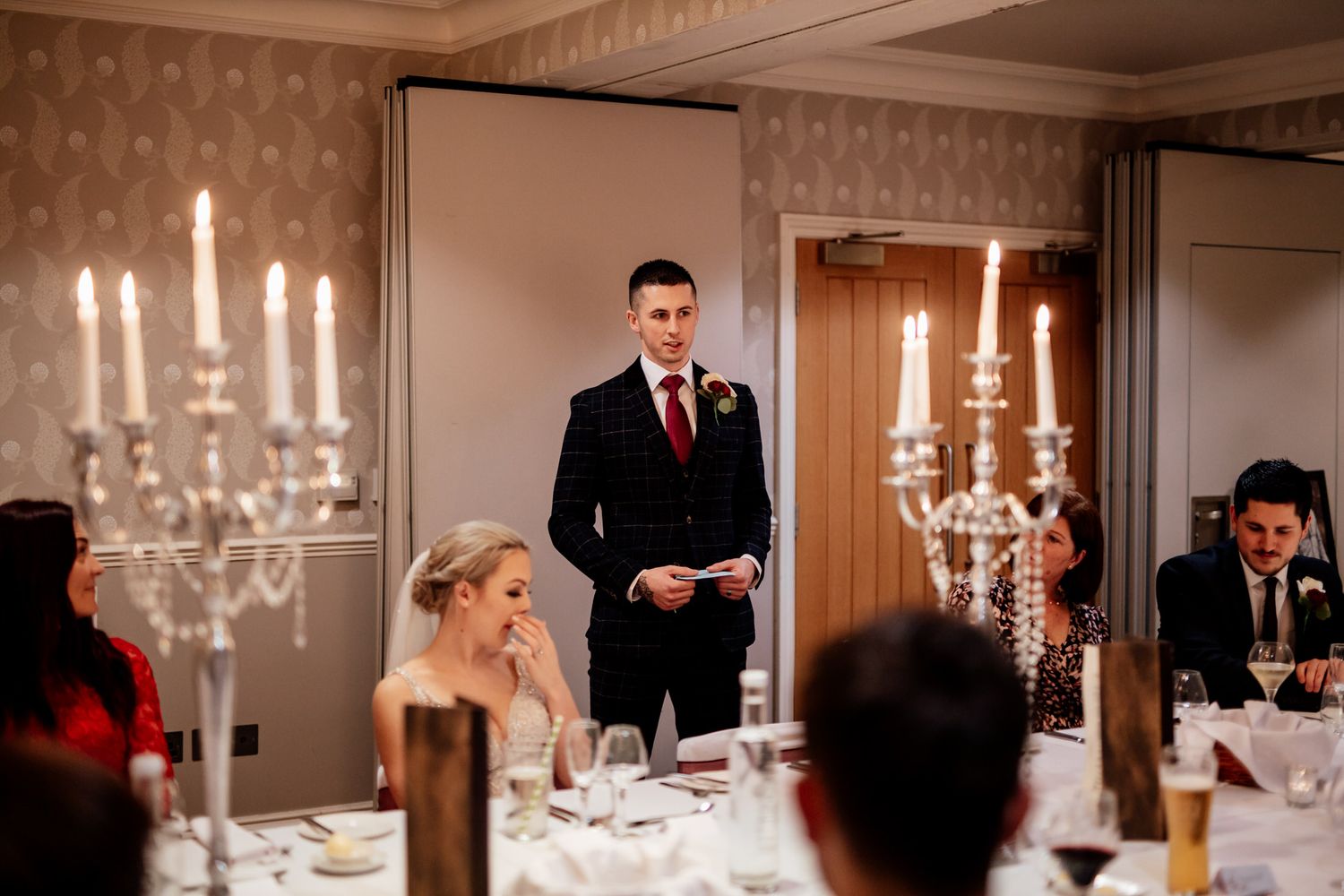 Candlelit wedding reception with elegant white tapered candles in crystal holders.
