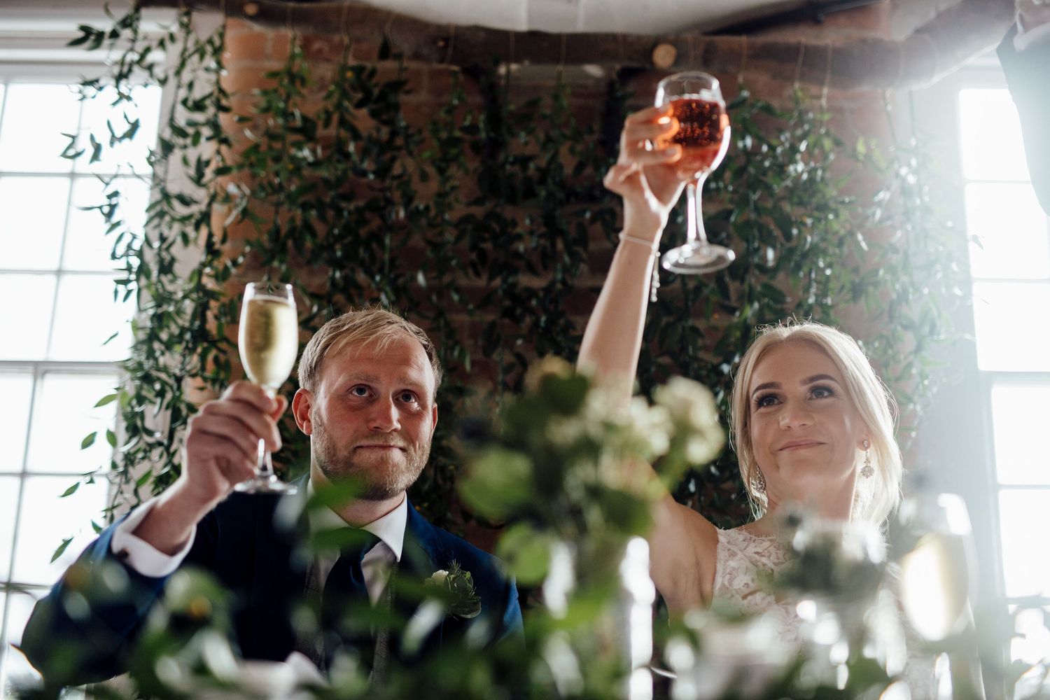 Wedding guests raising champagne glasses for celebratory toast.