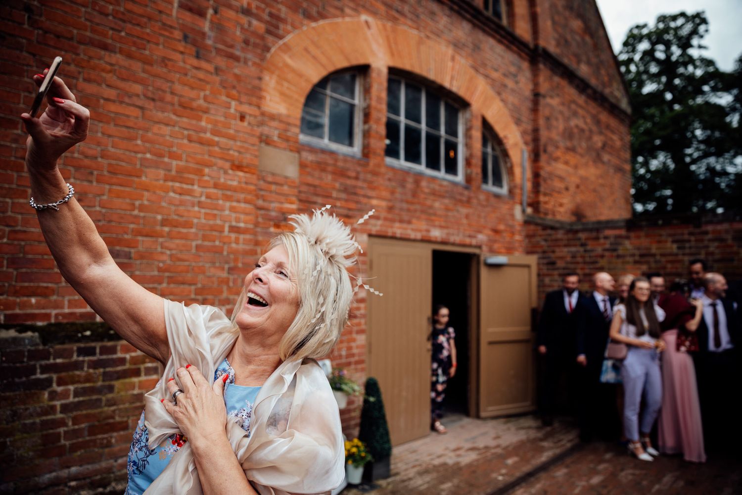 Joyful celebration outside historic brick venue with arched doorways.