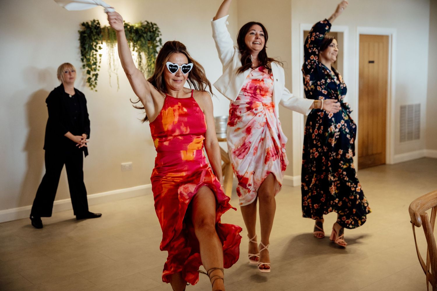 Lively dance floor scenes at wedding reception with guests in colorful attire.