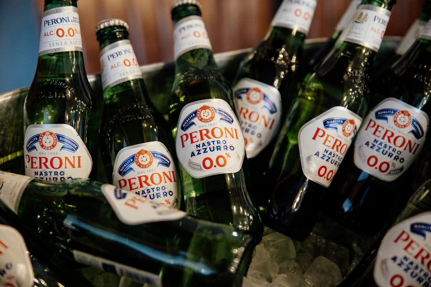Peroni beer bottles lined up at a wedding reception bar.