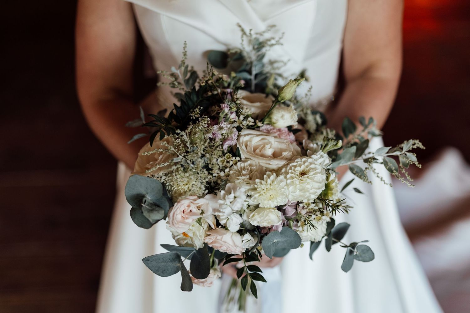 Romantic bridal bouquet featuring eucalyptus, white roses, and delicate greenery.