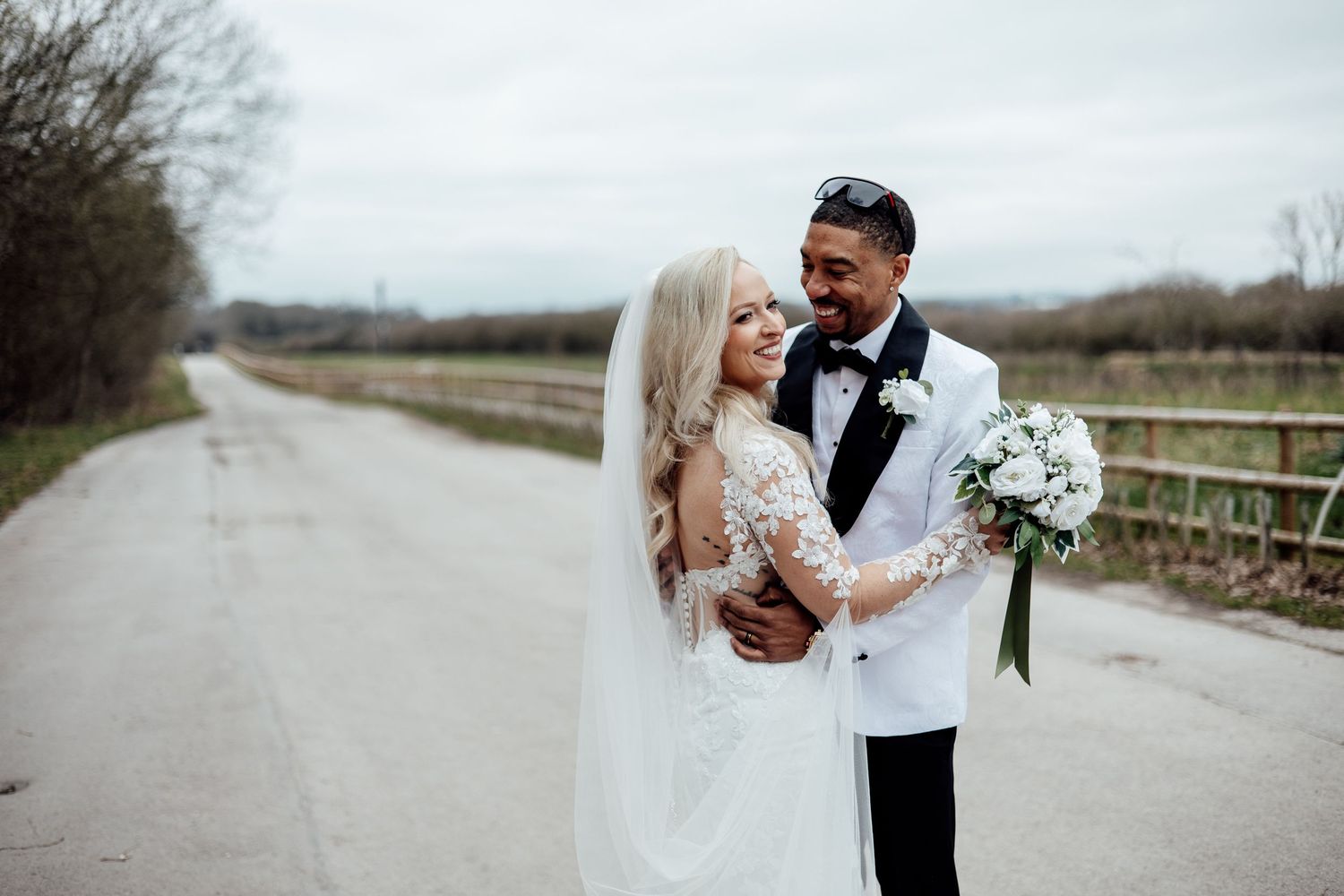 Bride and groom share a romantic moment on a quiet country road on their wedding day.