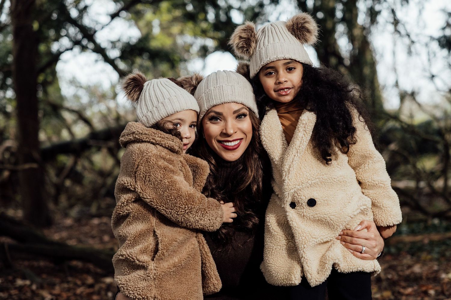 Candid moments of affection captured between people wearing cozy winter attire in a forest.