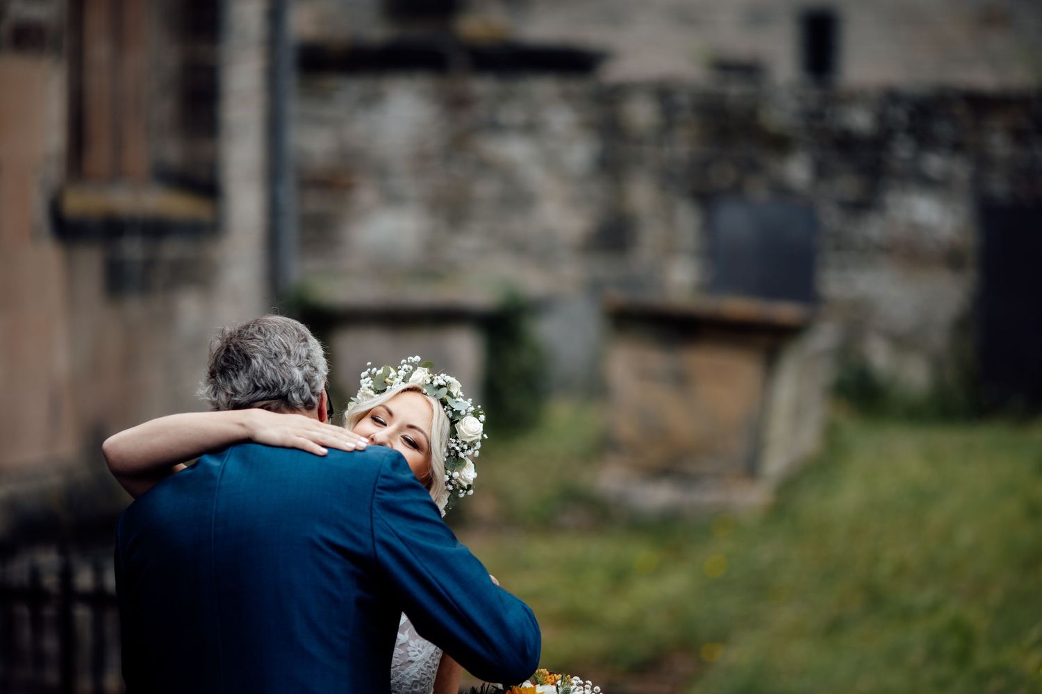 Emotional wedding celebration moments captured outdoors near stone buildings.
