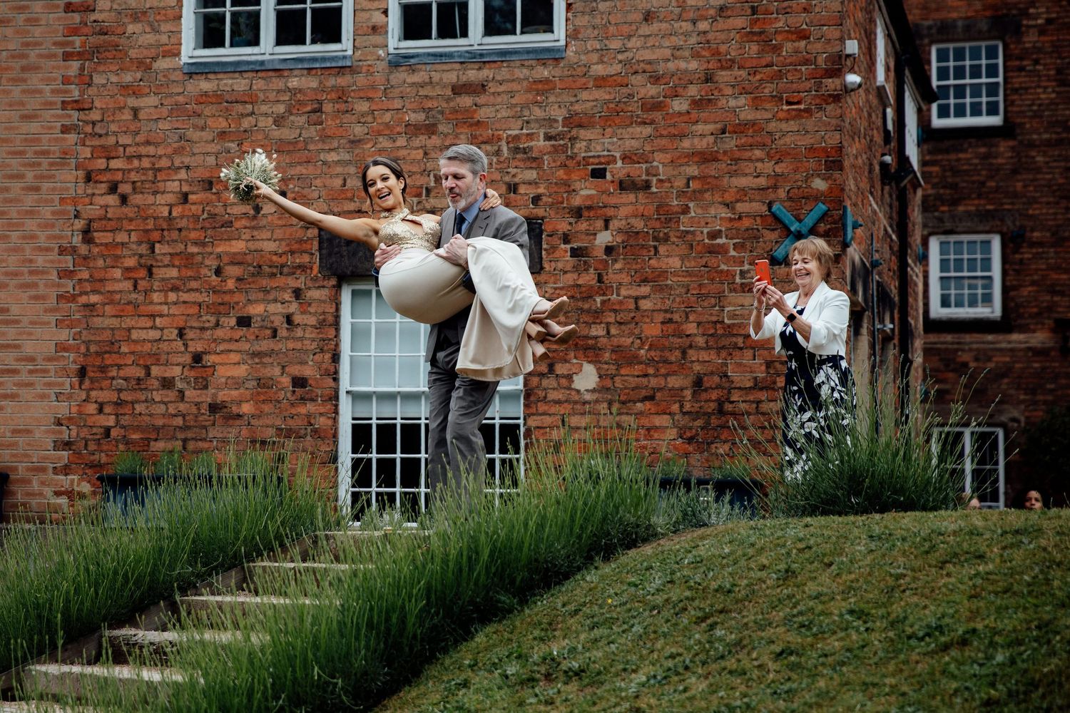 Brick building exterior with white window frames and green landscaping.