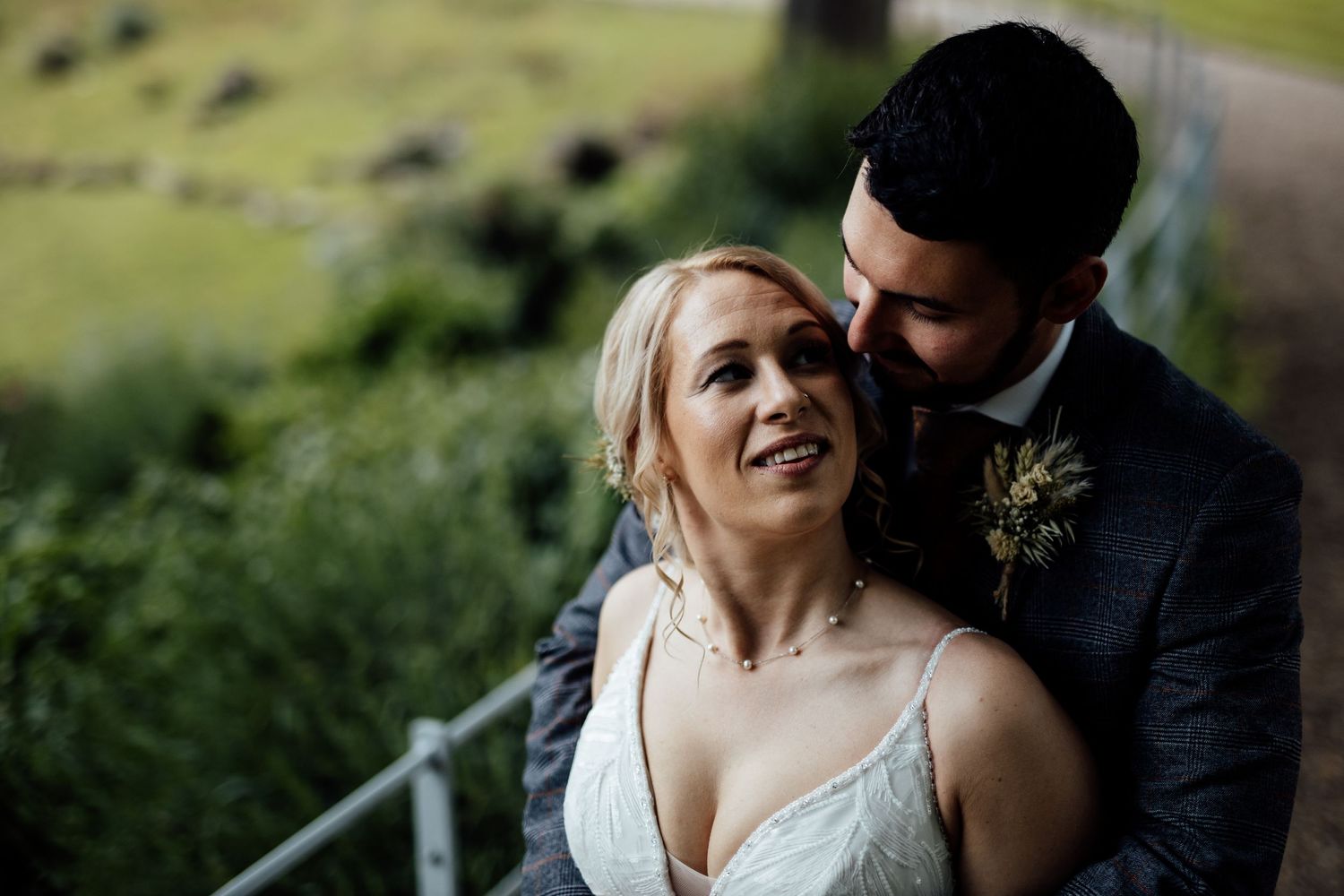 Romantic outdoor wedding portraits against natural greenery backdrop.
