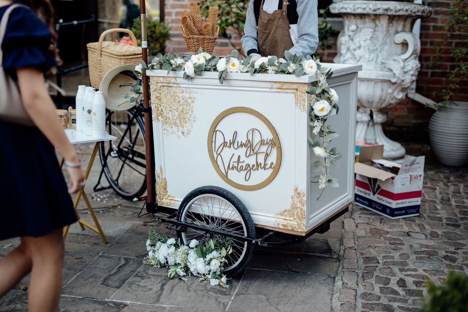 A decorated vintage cart with floral arrangements and gold accents at a wedding.