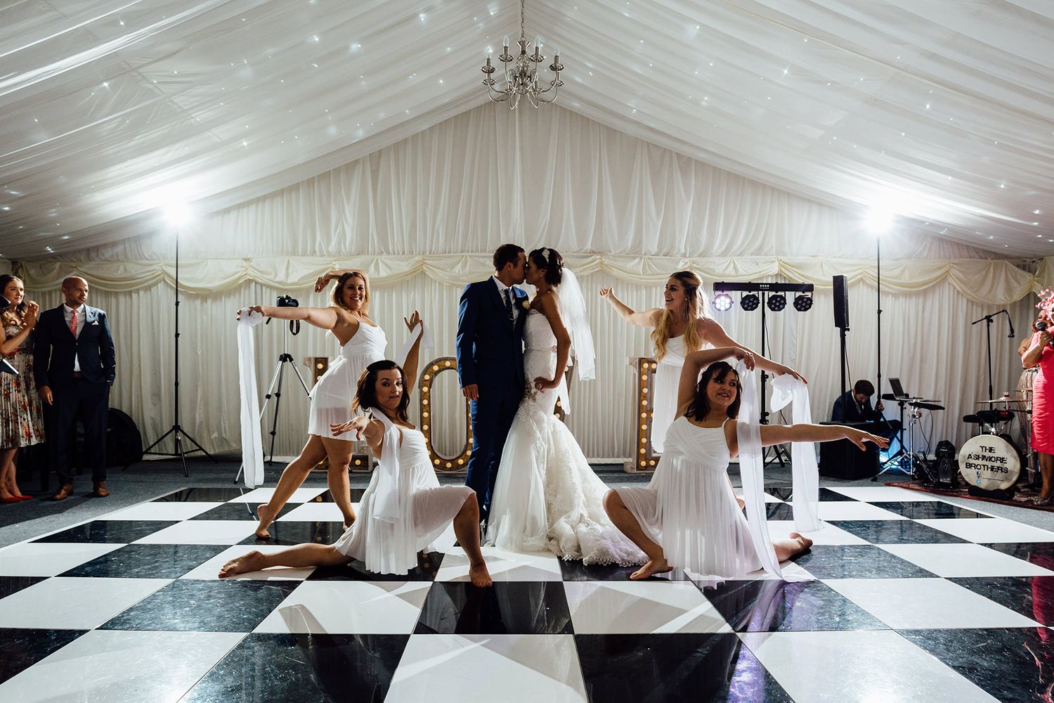 Wedding reception in an elegant white tent with black and white checkered dance floor.