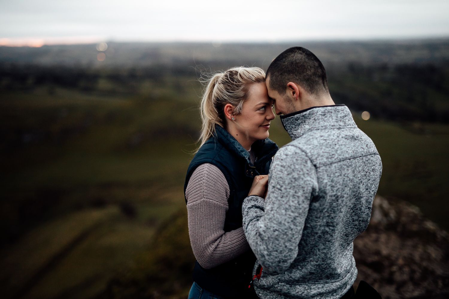Intimate moment shared between two people on a misty mountainside.