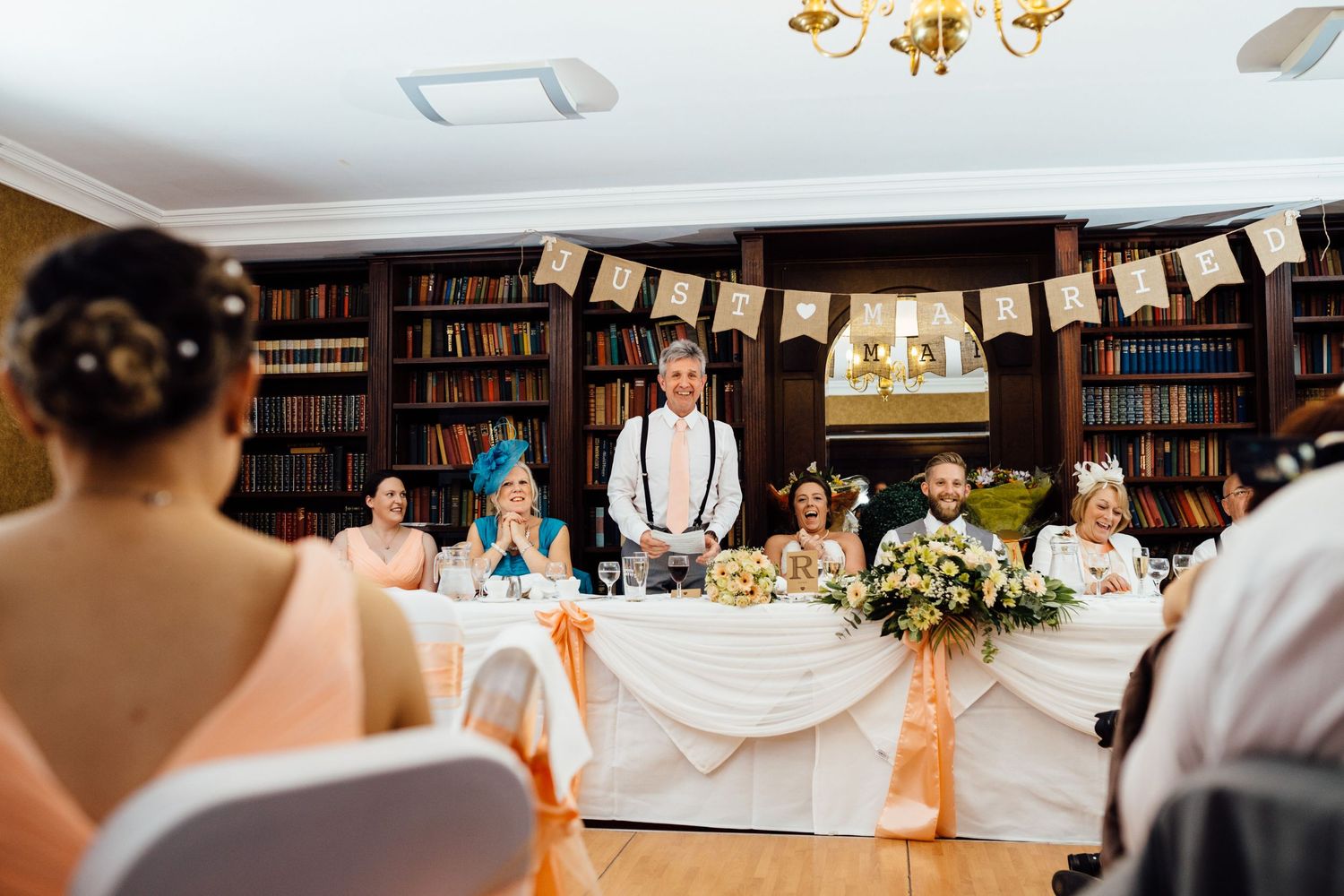 Library reception space decorated with hanging banners and elegant lighting fixtures.