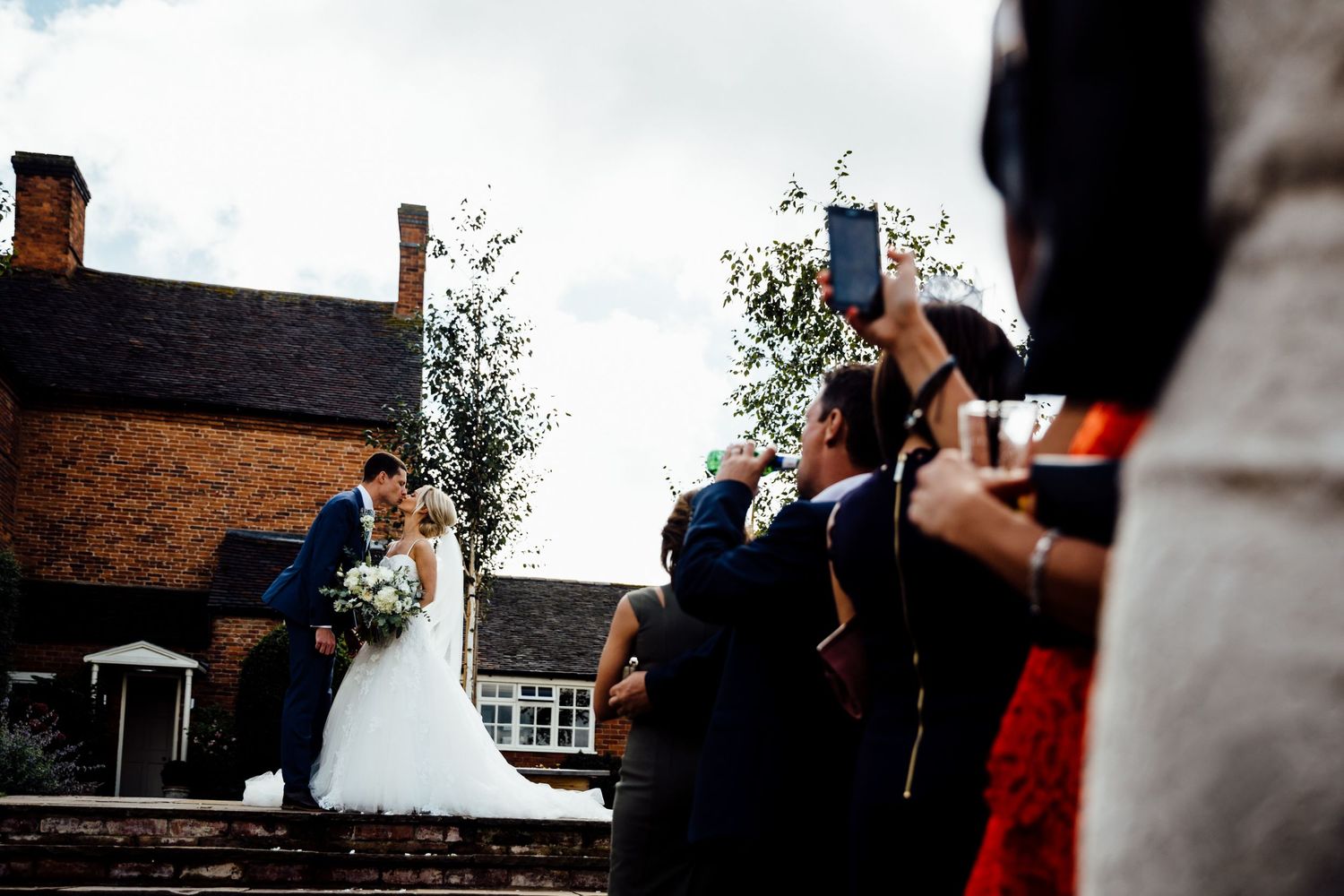Wedding celebration candid moments captured outside a brick venue.