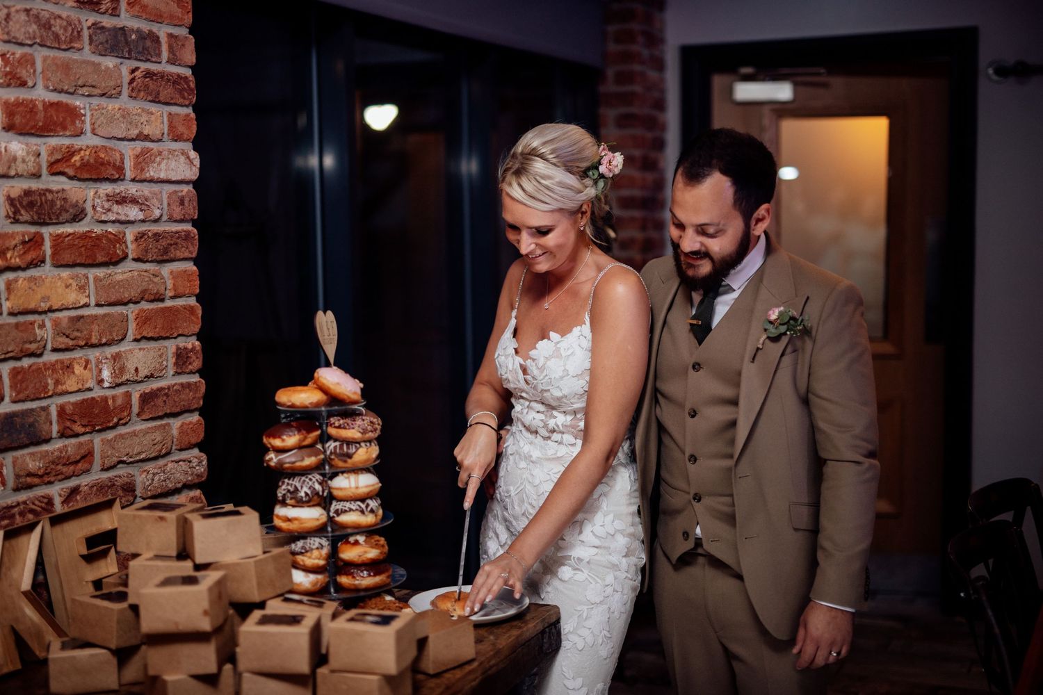 Wedding couple walking through an industrial-style venue with exposed brick walls.