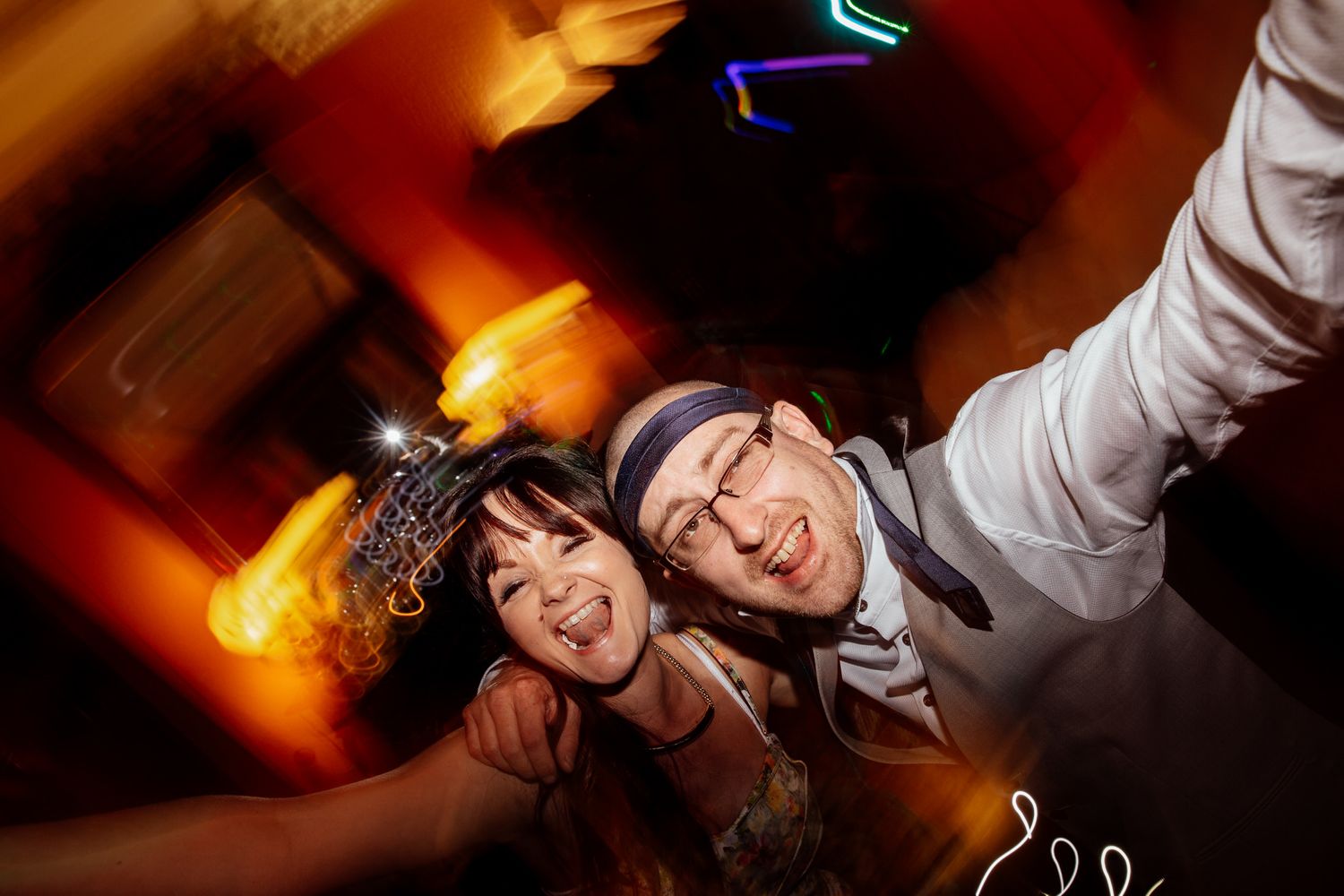 Wedding reception dance floor filled with celebratory energy under warm lighting.