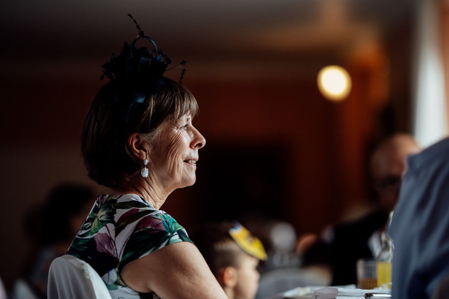 Wedding guests enjoying a candid moment during an indoor reception celebration.