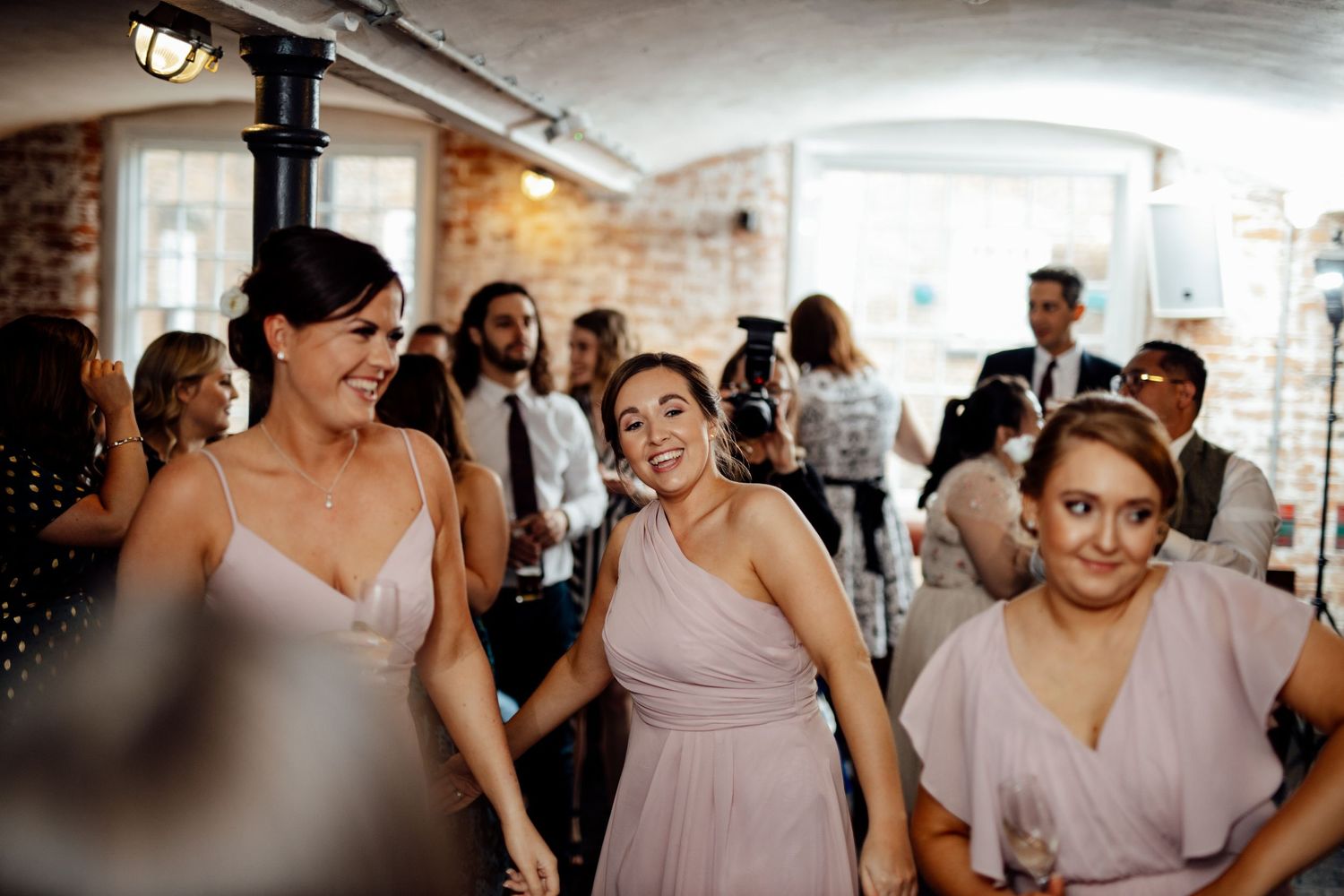 Wedding party gathered in an elegant venue with soft lighting.