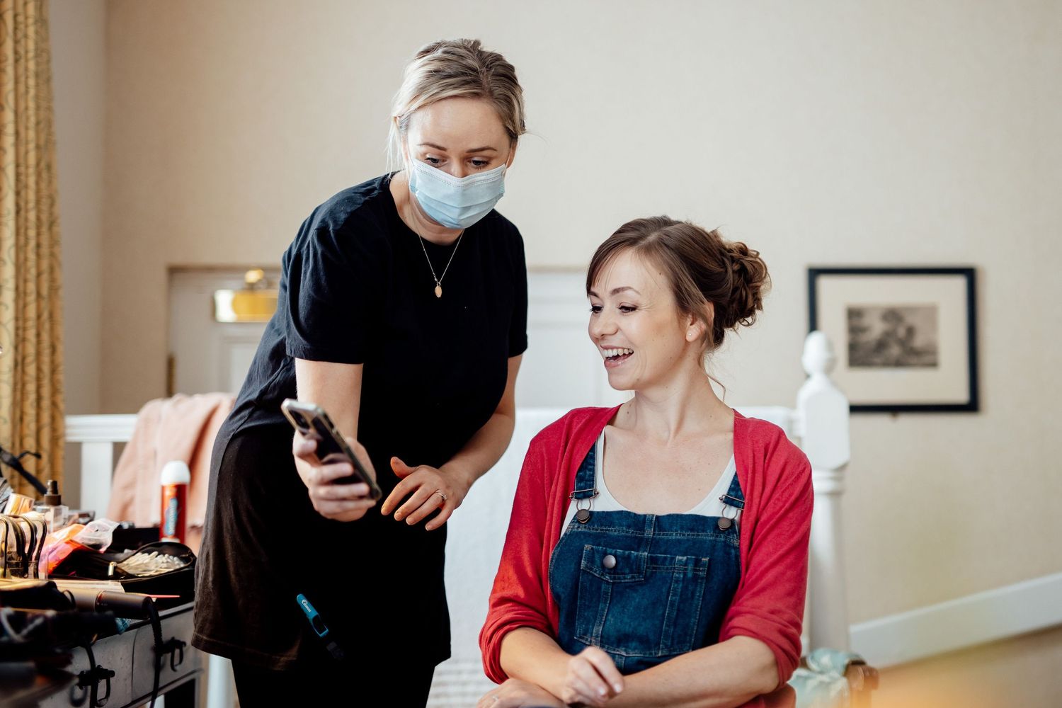 Wedding preparation scene in a bright room with red accents and natural lighting.