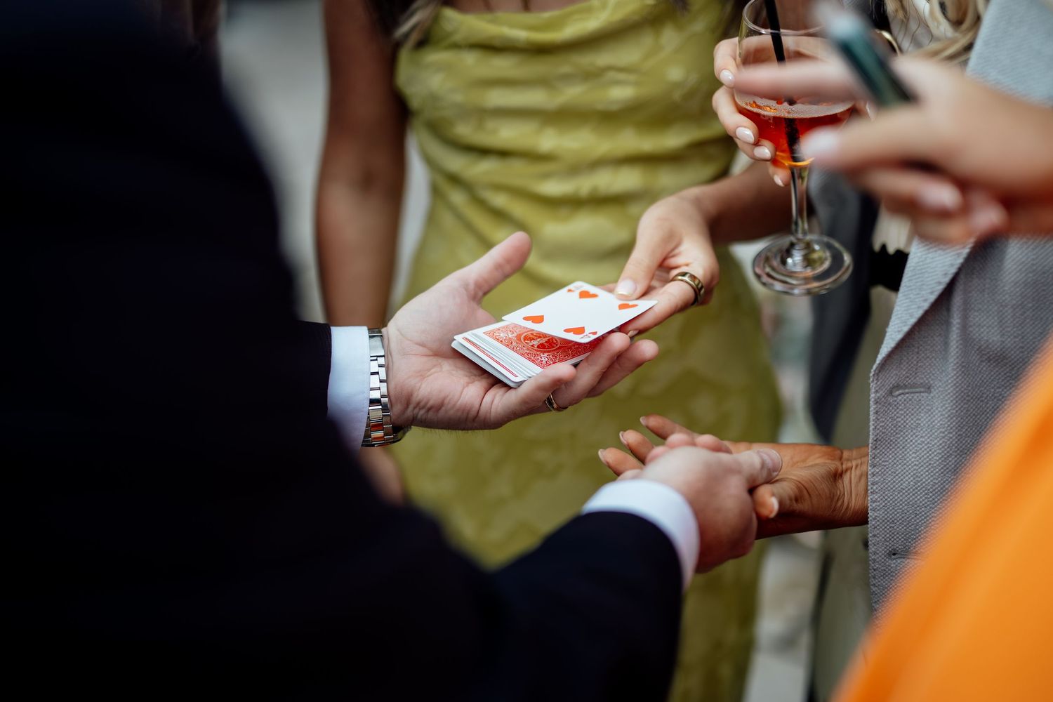 Wedding guests hold champagne glasses during an outdoor celebration.