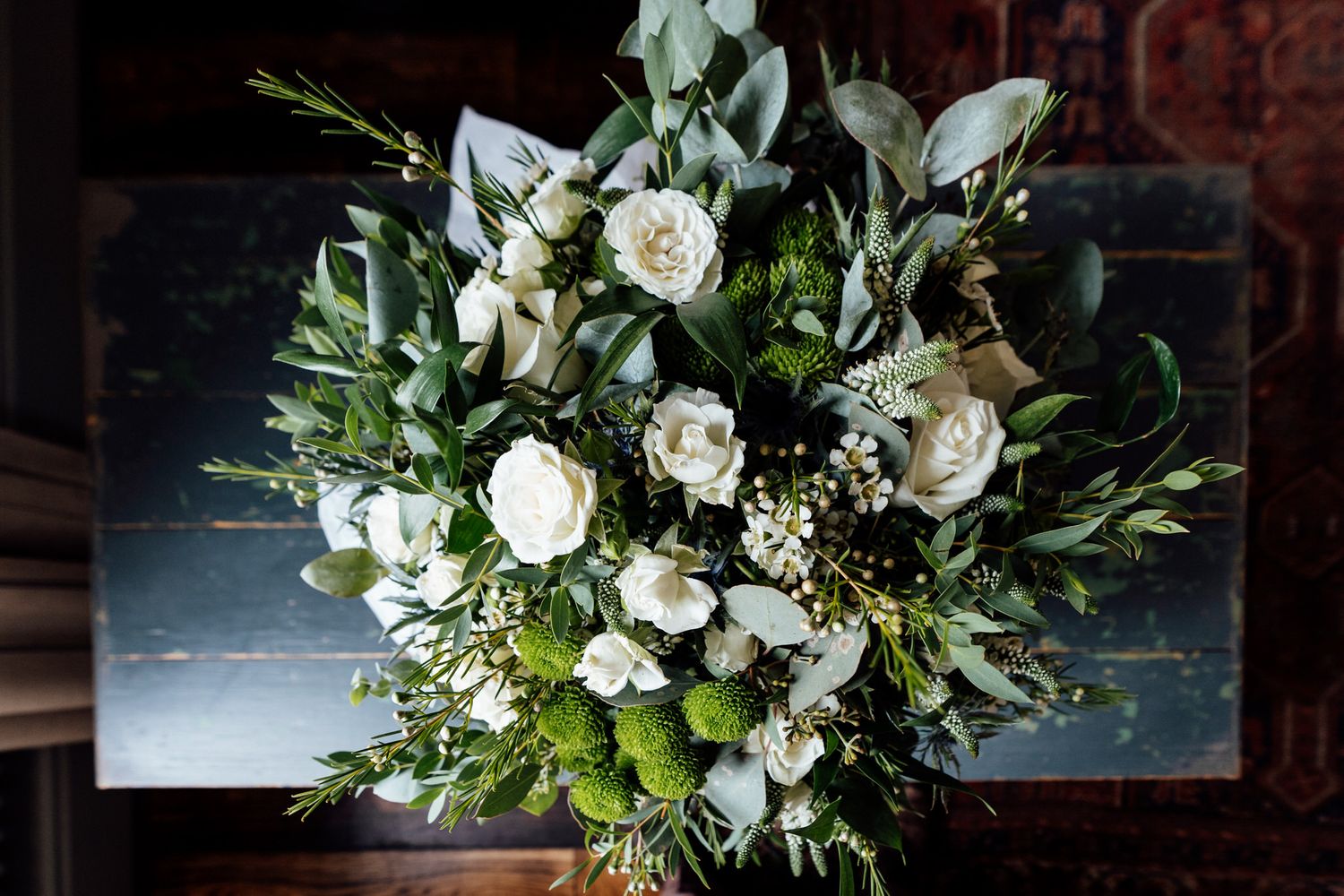 Elegant white floral wedding bouquets with roses and greenery arranged on display.