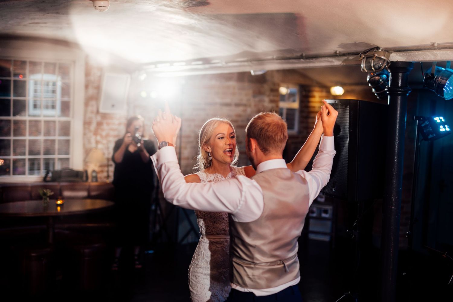 Wedding guests dancing and celebrating on the dance floor at an evening reception.