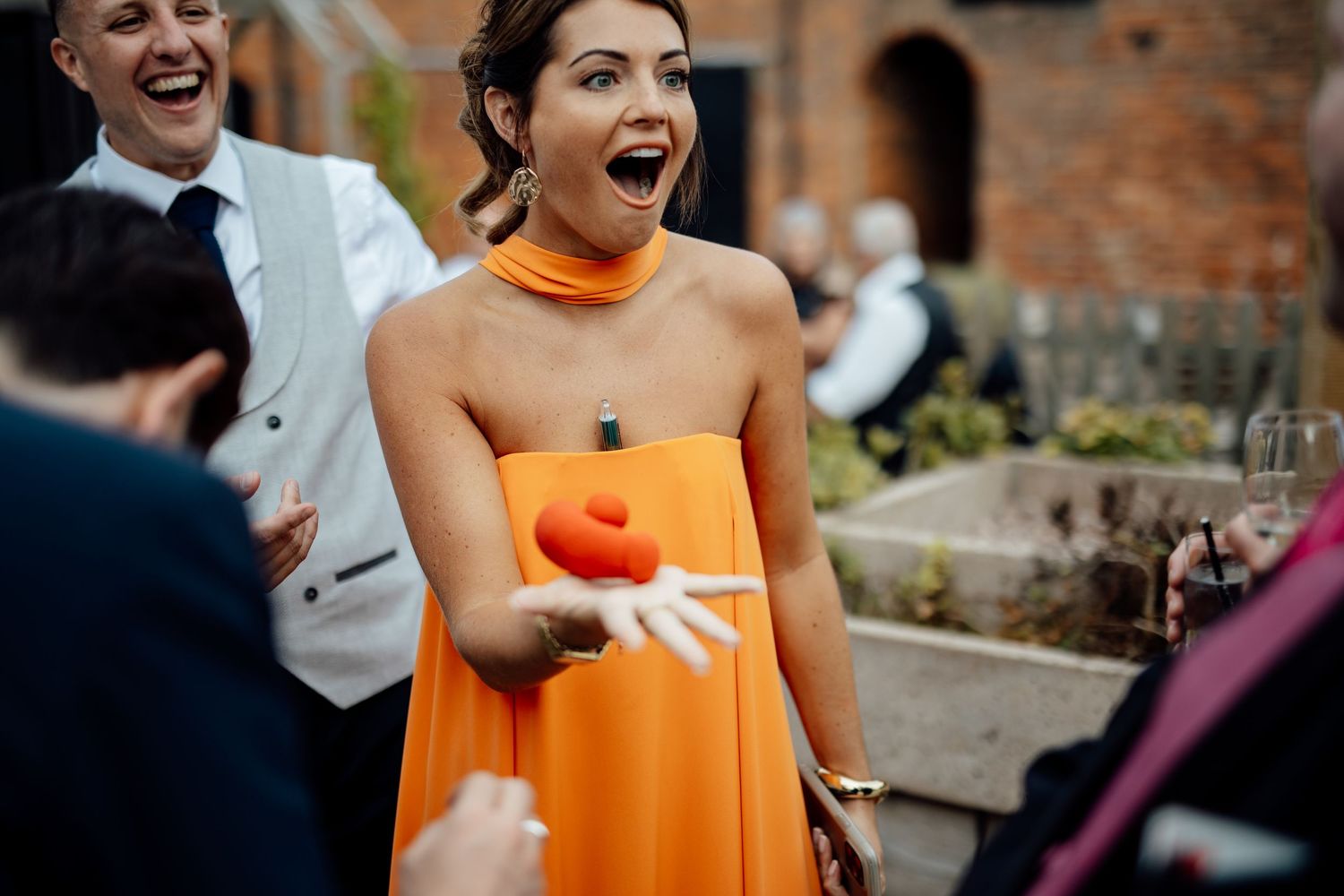 Wedding guests share laughter and smiles during an outdoor reception.