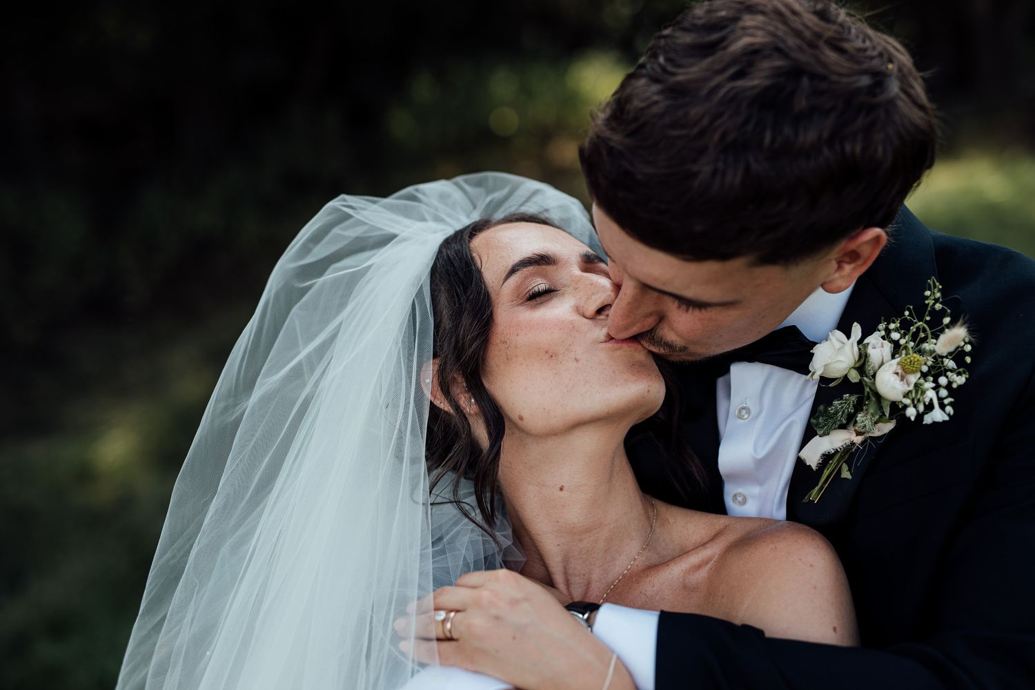 A romantic moment captured between newlyweds in an outdoor setting.