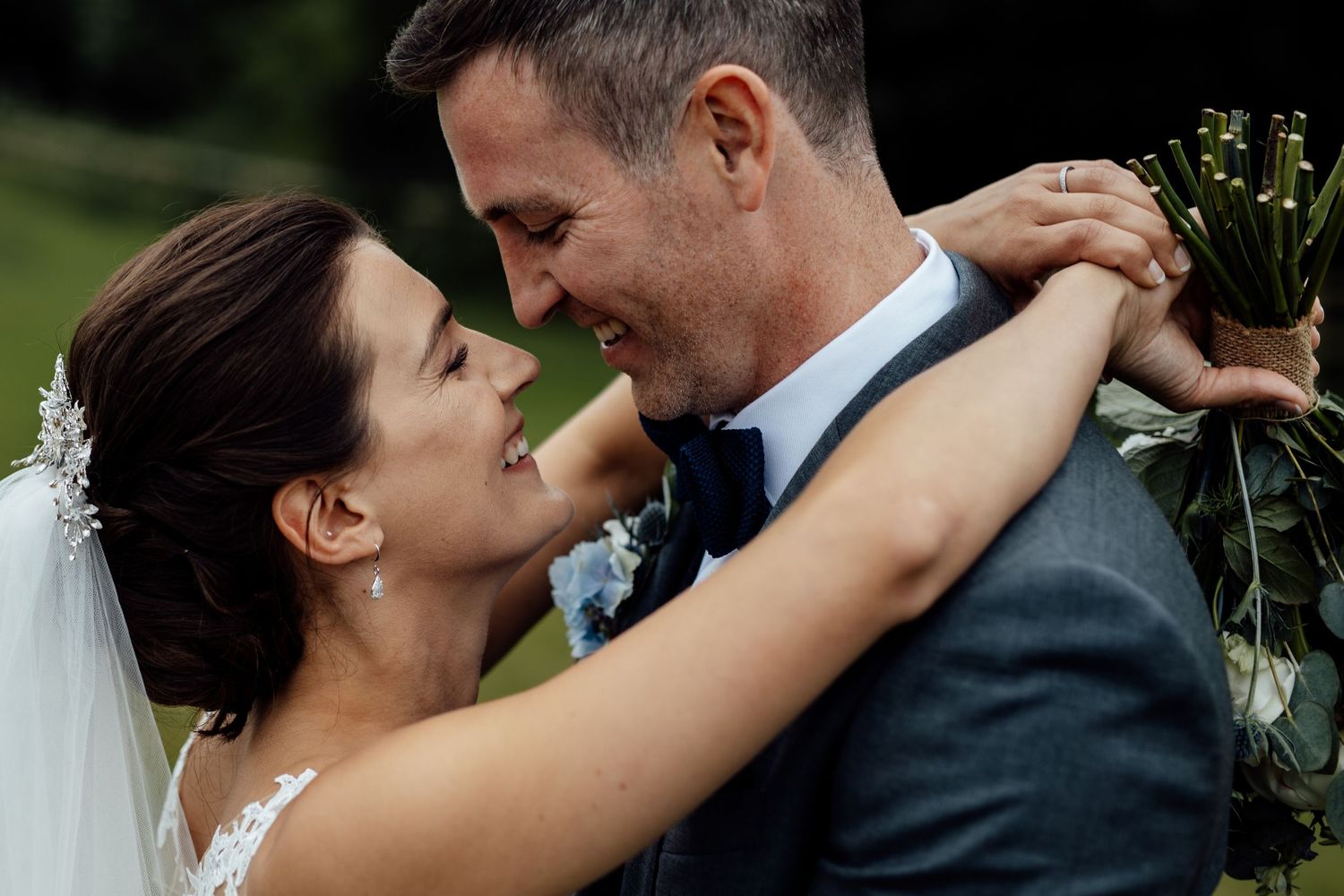 A tender moment between newlyweds embracing outdoors.