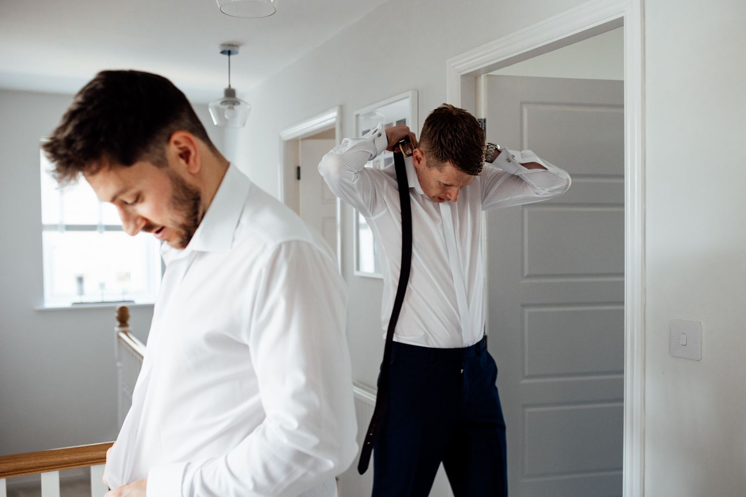 Wedding preparation moments captured in a bright, modern white room.