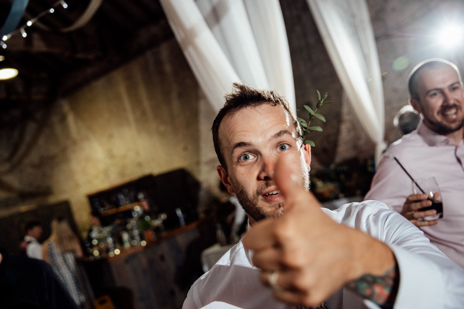 Guests celebrate at a lively indoor reception with ambient lighting.