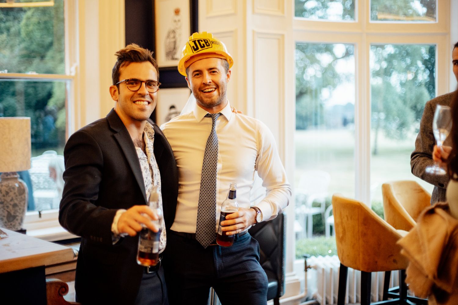 Wedding guests enjoying drinks and conversation in a bright indoor venue.
