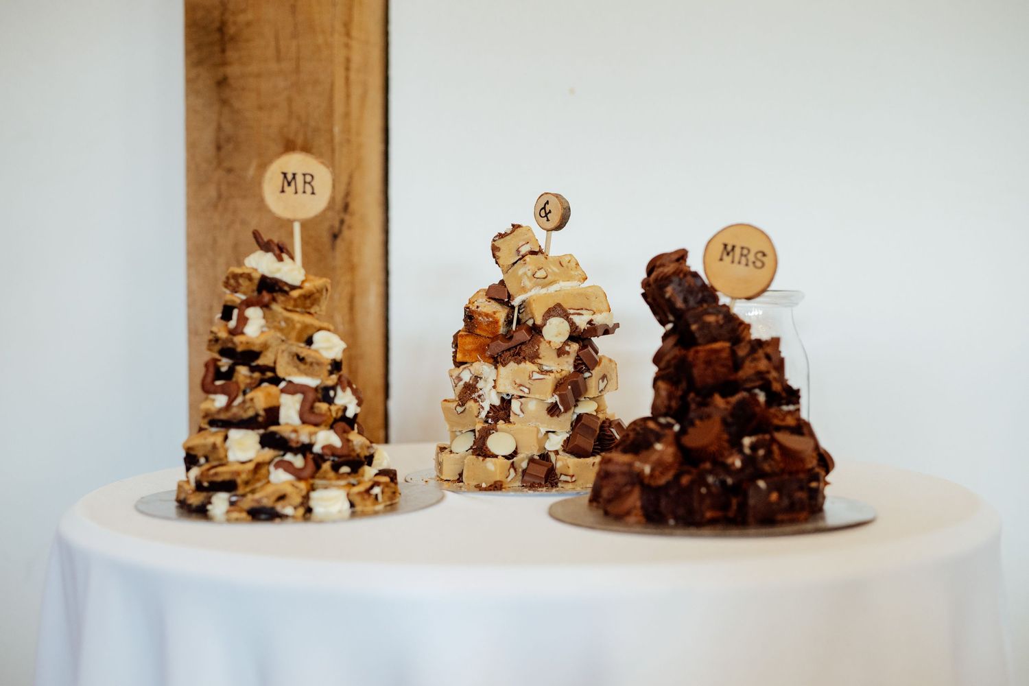 Display of artisanal fudge and desserts arranged on white serving platters.