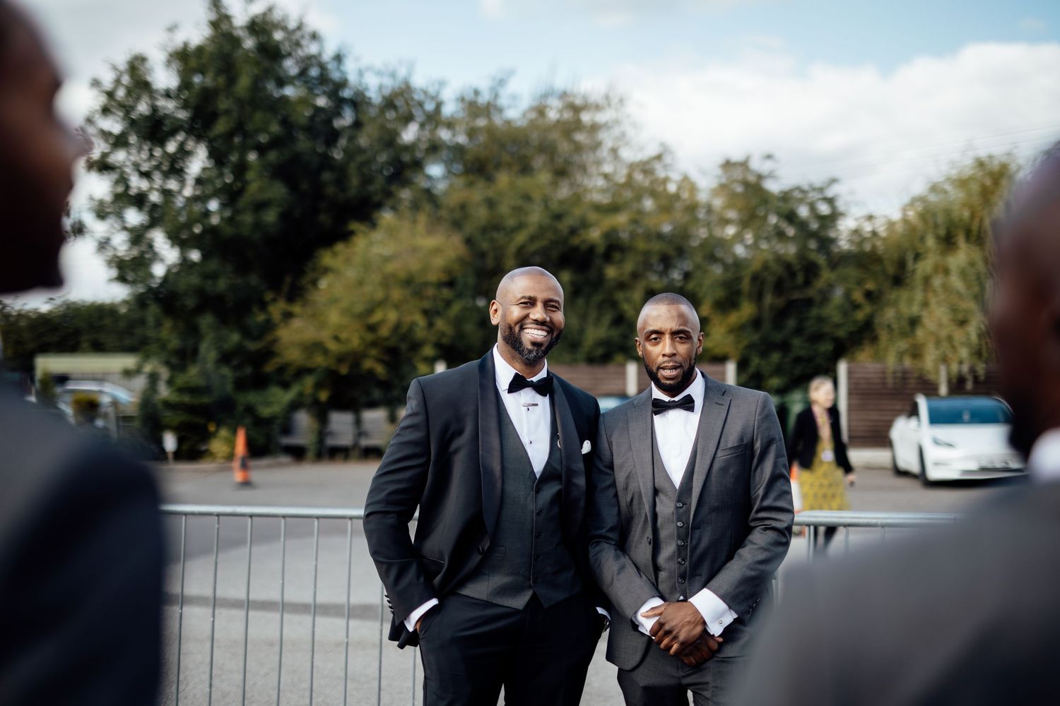 Wedding party members in formal attire gathered outdoors.