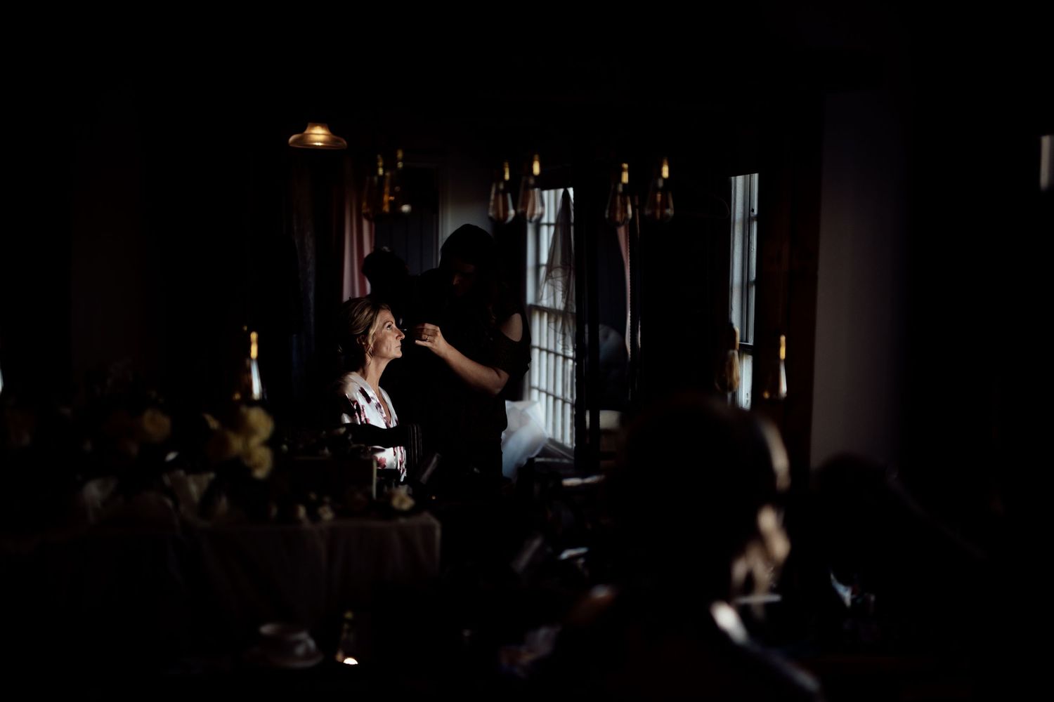 Dimly lit indoor venue with atmospheric lighting and silhouettes.