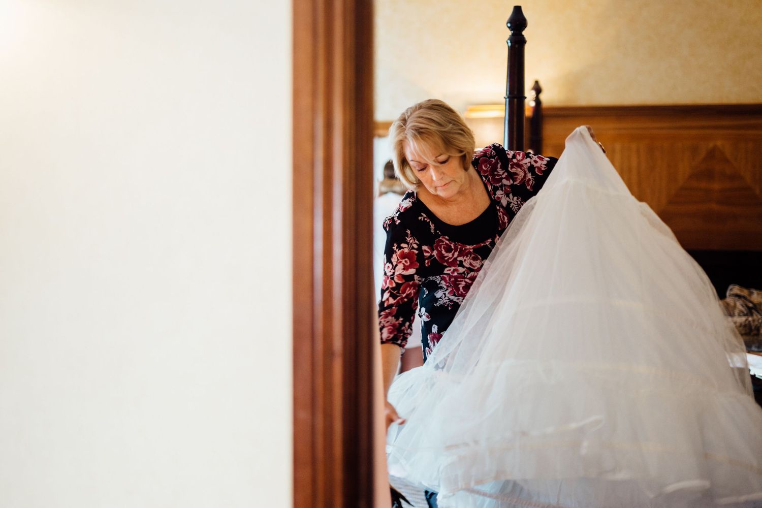 White wedding dress detail with natural window lighting in an elegant room.