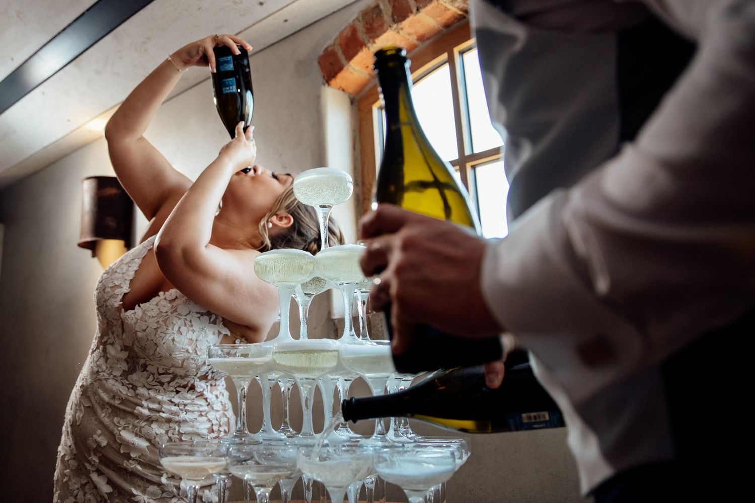 Champagne being poured into crystal glasses during wedding celebration.