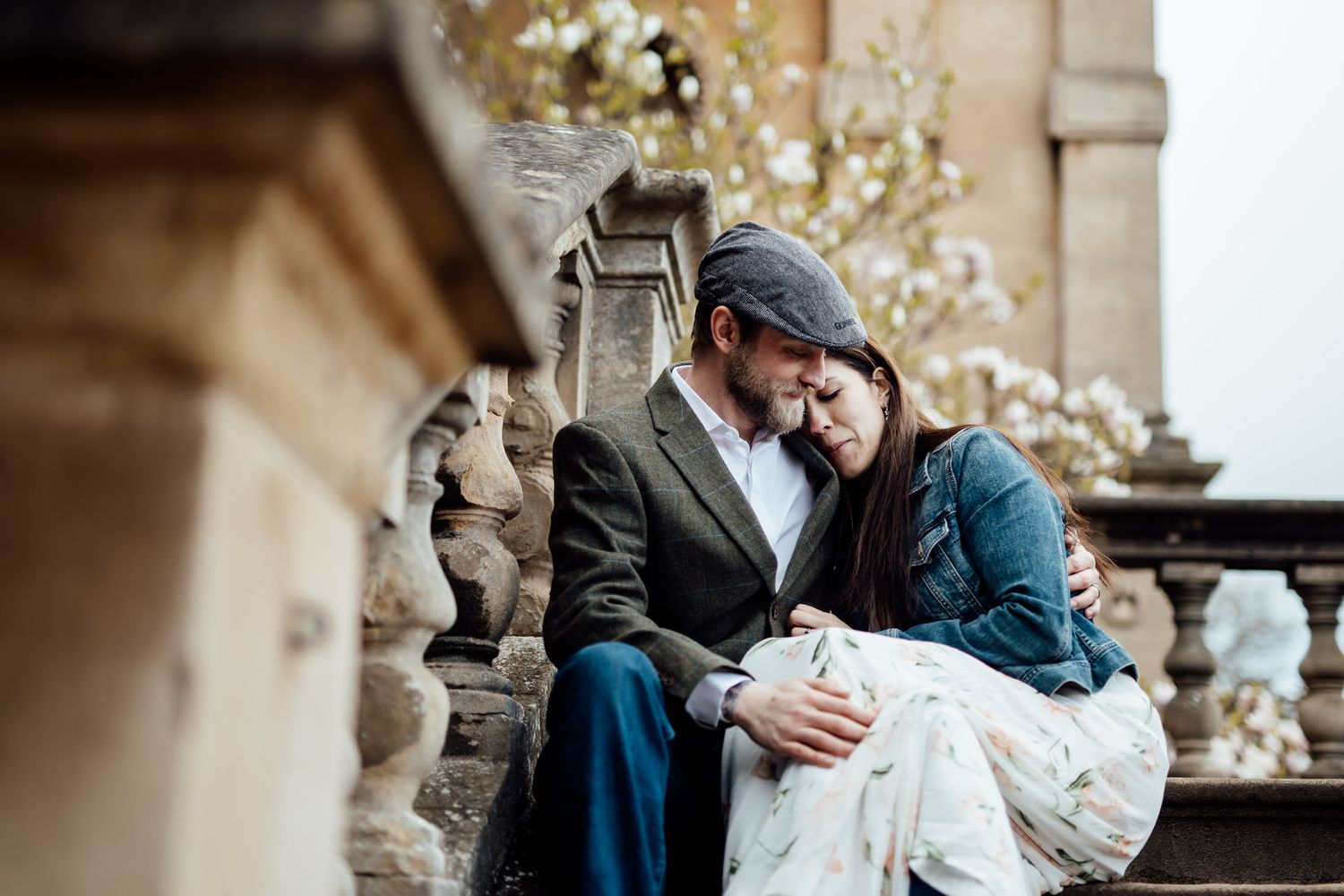 Intimate moment between couple on ornate stone balcony.
